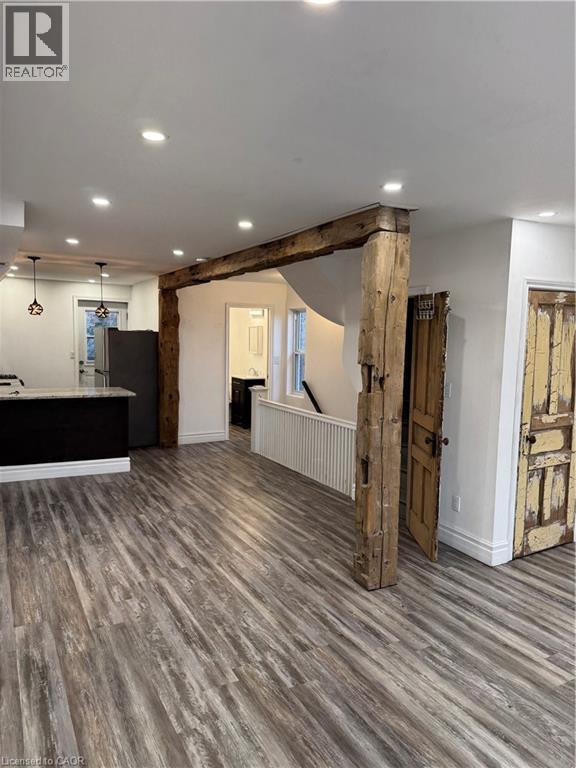 A spacious room with wooden floors and a large wooden beam on the ceiling.