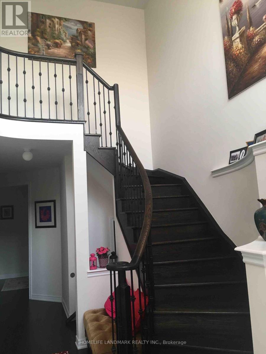 A staircase with a black railing and a brown ottoman.