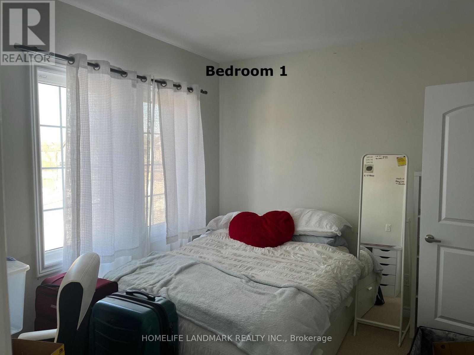 Bedroom 1 has a bed with a red pillow and a white chair.
