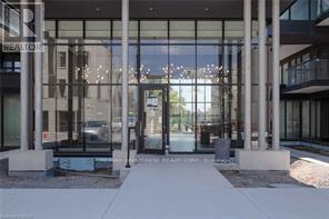 The image shows the front of a real estate office with a glass door and a walkway leading to it.