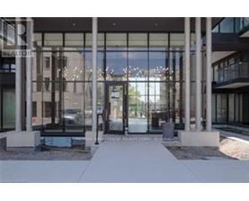 The image shows the front of a real estate office with a glass door and a walkway leading to it.