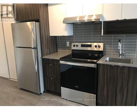 A modern kitchen with a stainless steel refrigerator, oven, and sink.
