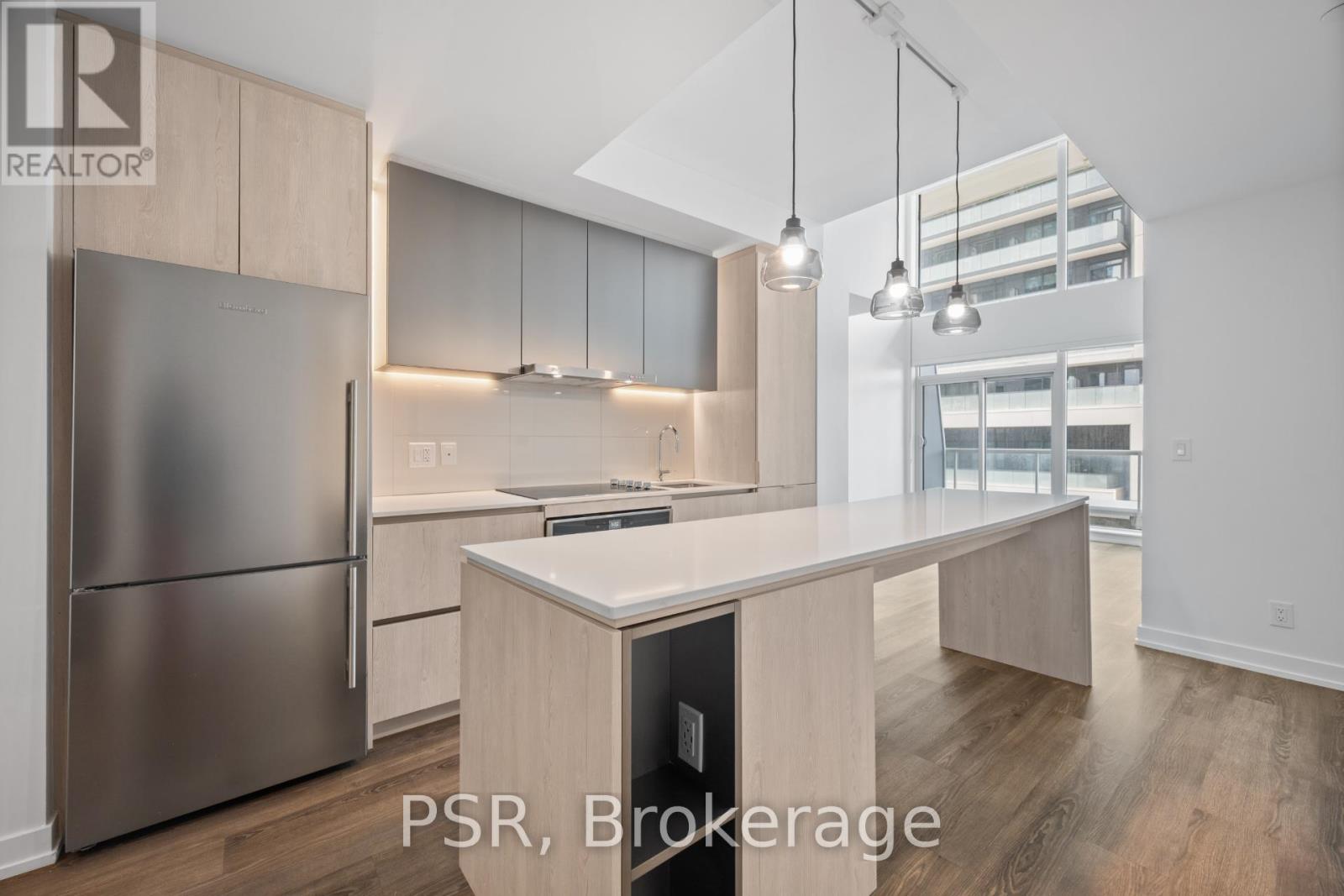 A modern kitchen with stainless steel appliances and wooden cabinets.