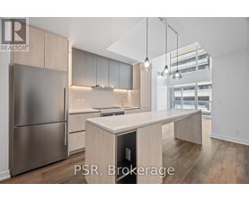 A modern kitchen with stainless steel appliances and wooden cabinets.