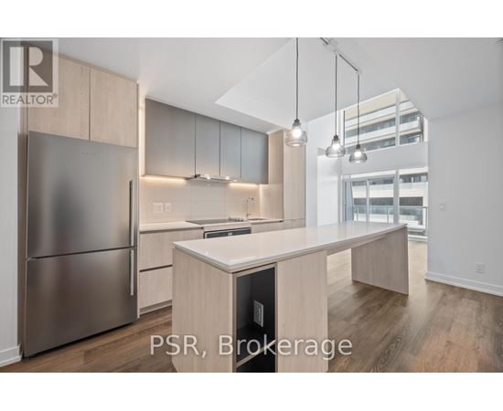 A modern kitchen with stainless steel appliances and wooden cabinets.