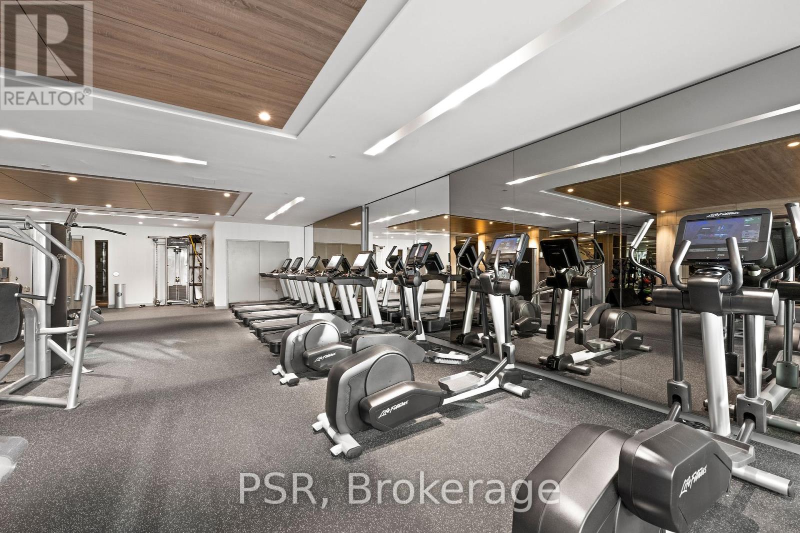A gym with a variety of equipment including treadmills, weights, and exercise machines.