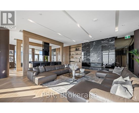 A modern living room with a large sectional sofa and a coffee table in the center.
