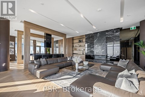 A modern living room with a large sectional sofa and a coffee table in the center.