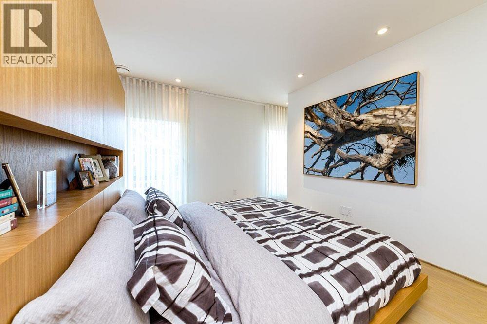 A bedroom with a large bed and a painting on the wall.