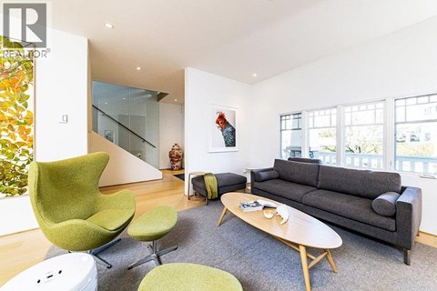 A living room with a green chair and a grey couch.