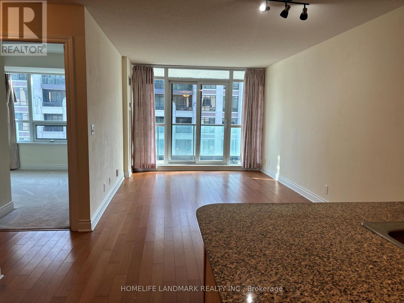 A room with wooden floors and a carpeted area.