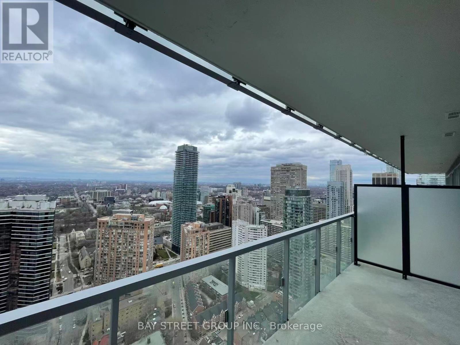 A balcony overlooks a cityscape with buildings of various heights.