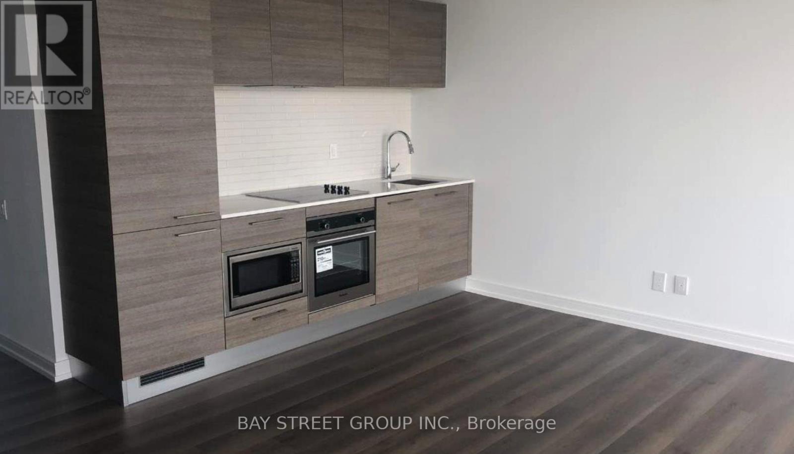 A modern kitchen with a wooden cabinet and a stainless steel sink.