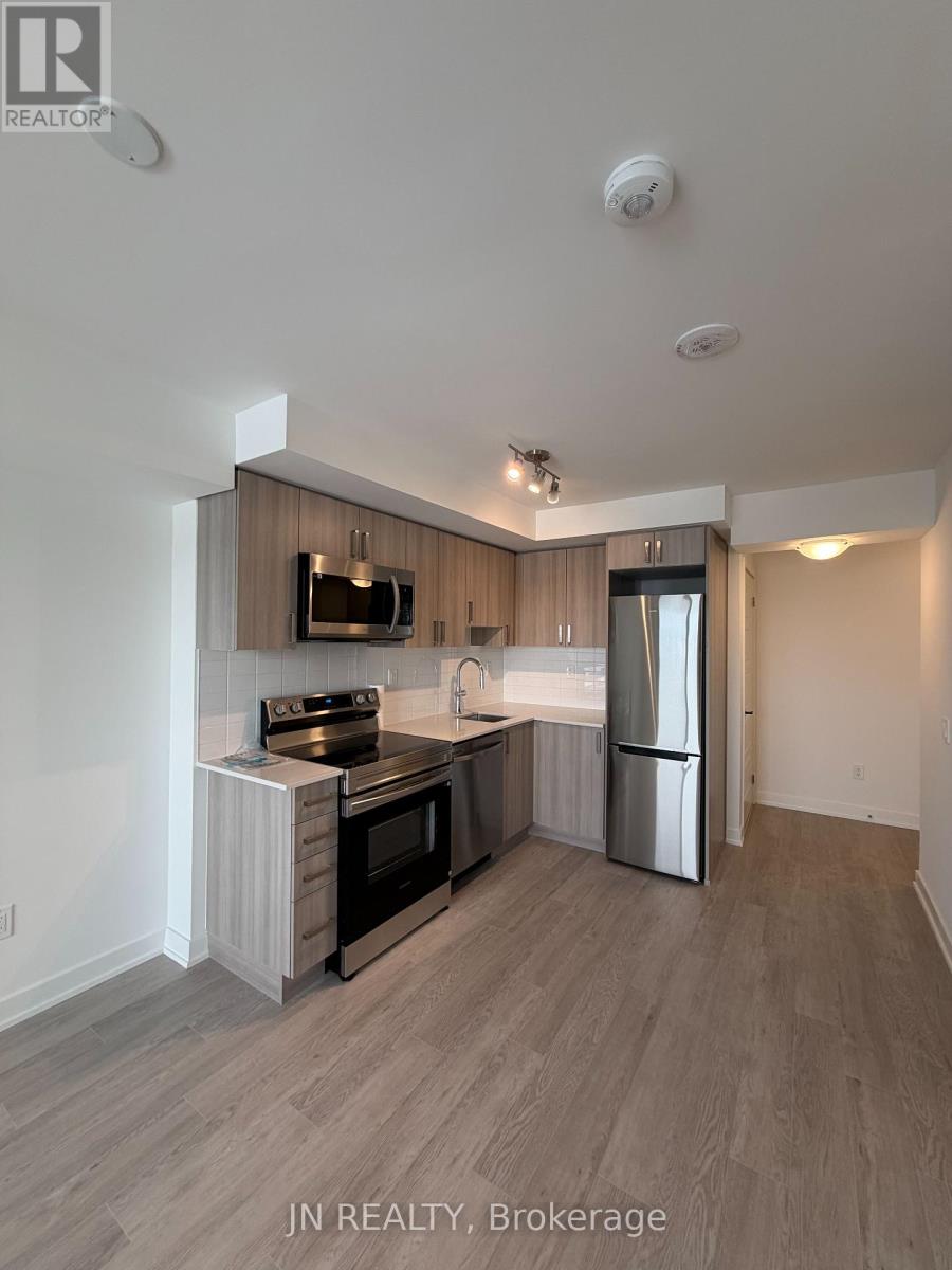 A modern kitchen with a refrigerator, stove, and oven.