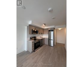 A modern kitchen with a refrigerator, stove, and oven.