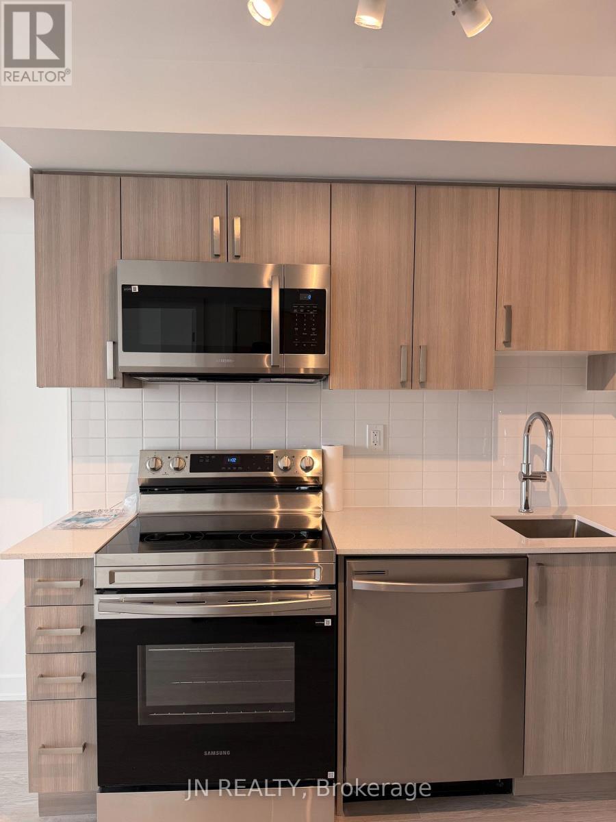 A modern kitchen with a stove, oven, microwave, and cabinets.