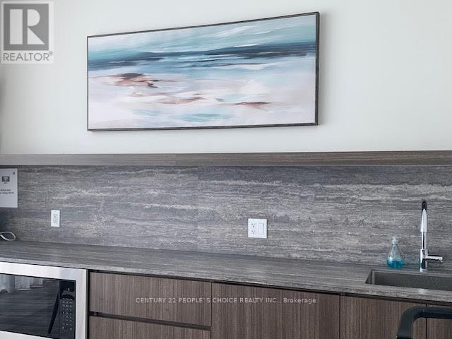 A painting hangs on a wall above a kitchen counter.