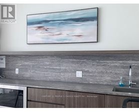 A painting hangs on a wall above a kitchen counter.