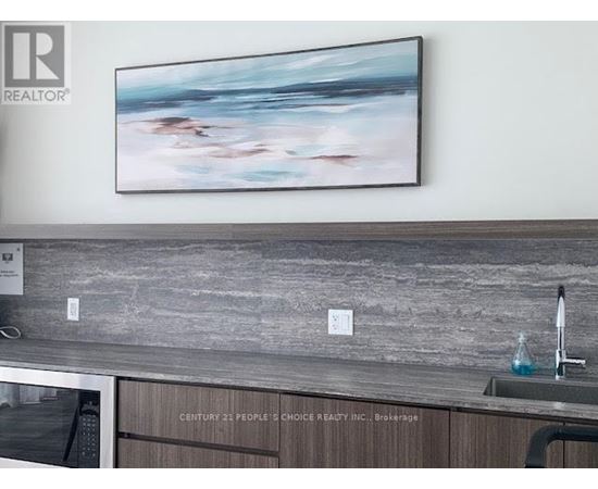 A painting hangs on a wall above a kitchen counter.