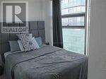 A bedroom with a bed and a window.