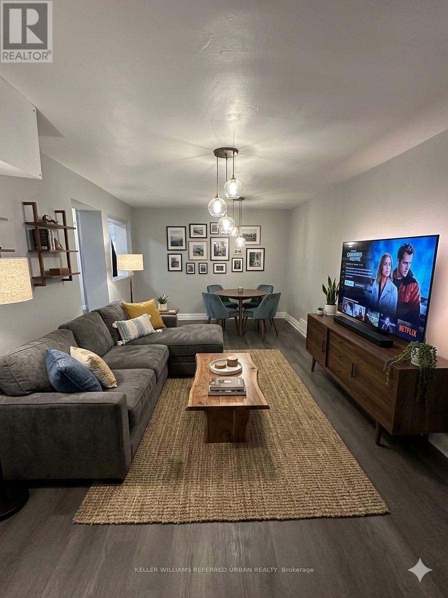 A living room with a grey couch, a coffee table, a flat screen TV and a rug.