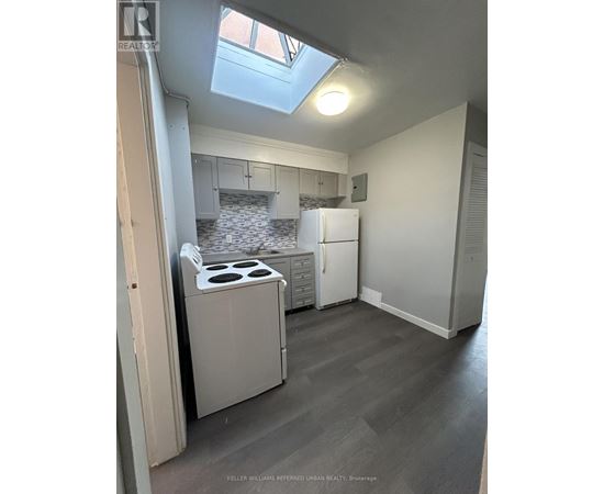 A kitchen with a stove top oven and a refrigerator.