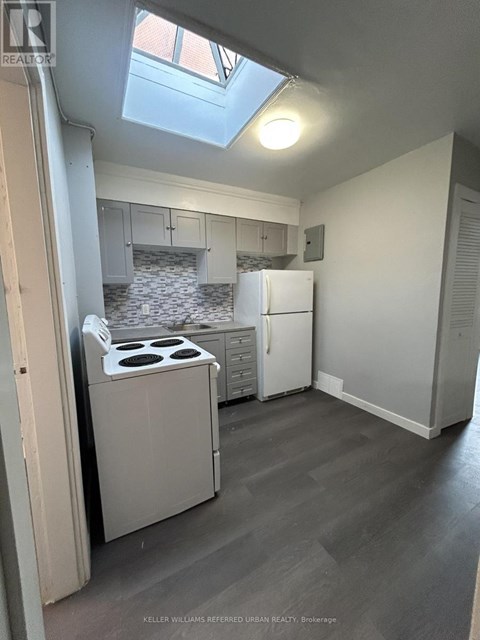 A kitchen with a stove top oven and a refrigerator.