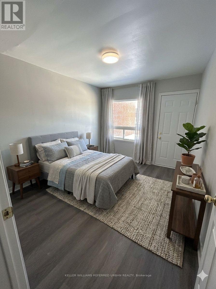 A bedroom with a bed, nightstand, and window.