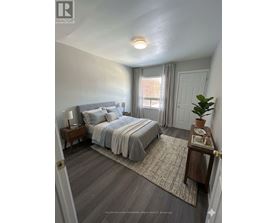 A bedroom with a bed, nightstand, and window.