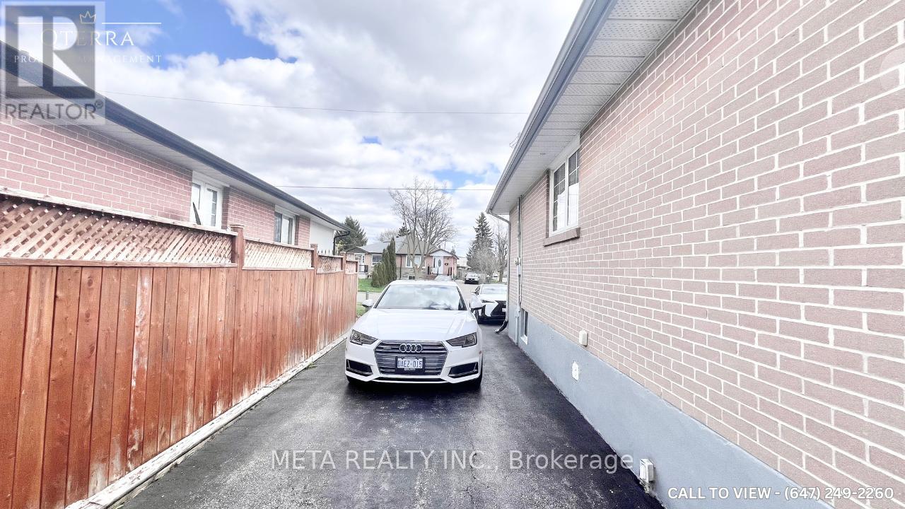 A car is parked on a wet street between two brick buildings.
