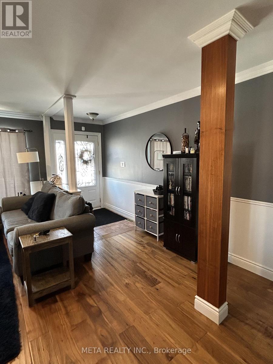 A living room with a grey couch and a wooden floor.