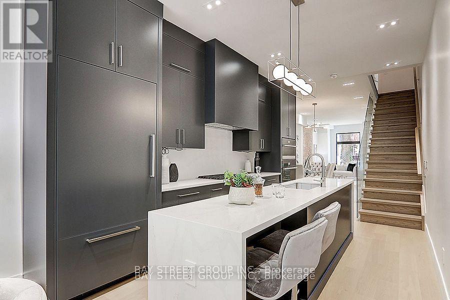 A modern kitchen with dark cabinets and a white countertop.