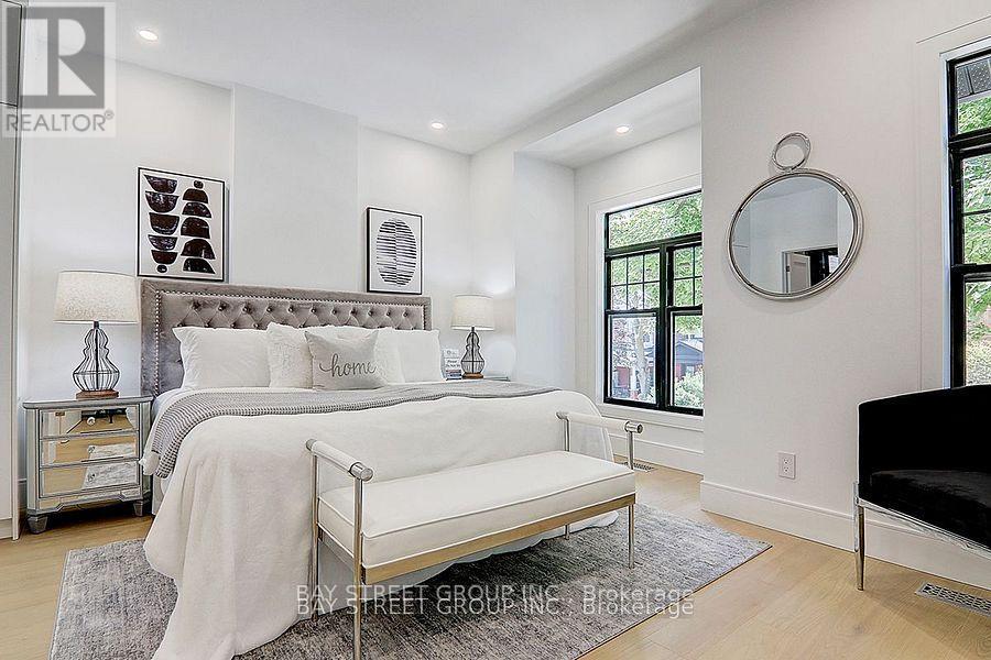 A bedroom with a bed, nightstand, and a mirror on the wall.