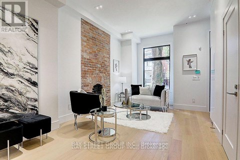 A living room with a black chair and a glass table.