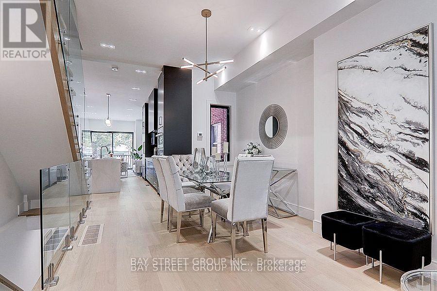 A modern dining room with a glass table and chairs.