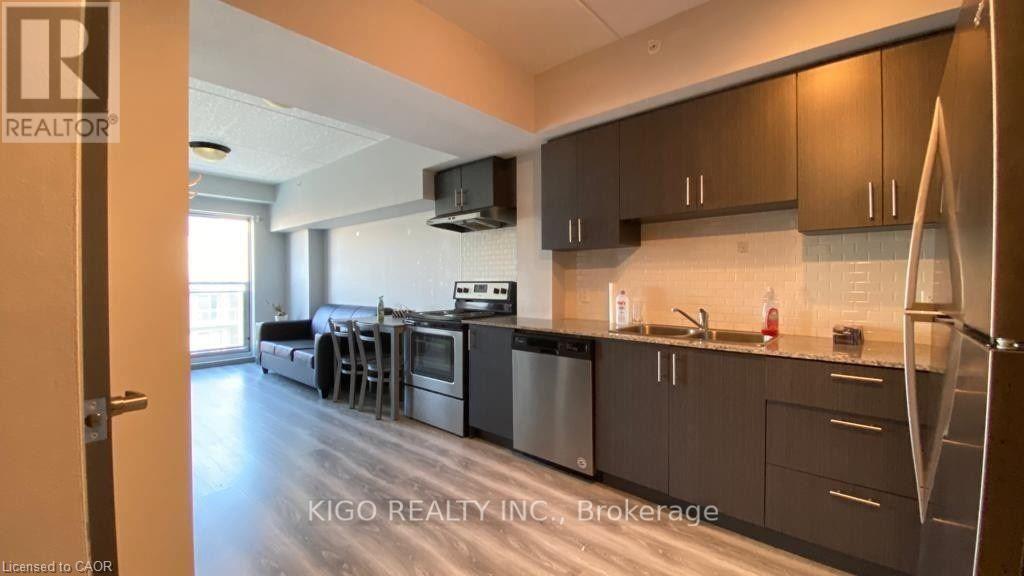 A modern kitchen with dark wood cabinets and stainless steel appliances.