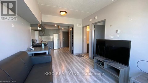 A living room with a grey couch and a black television.