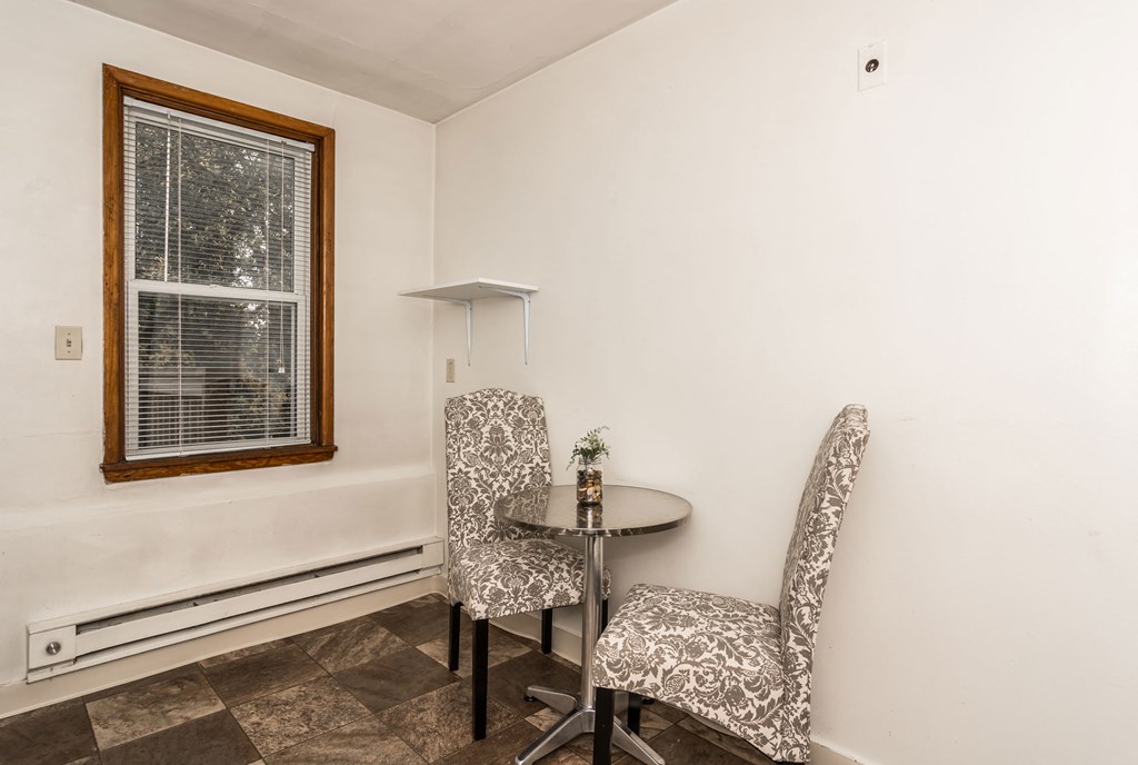 a small dining room with two chairs and a table