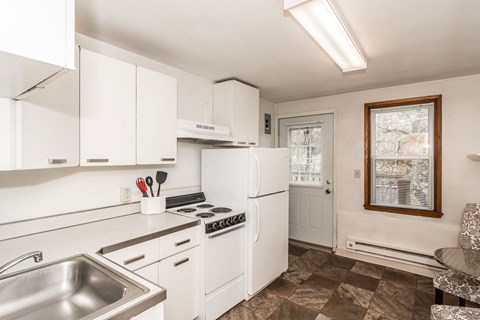 a kitchen with white cabinets and a sink and a refrigerator