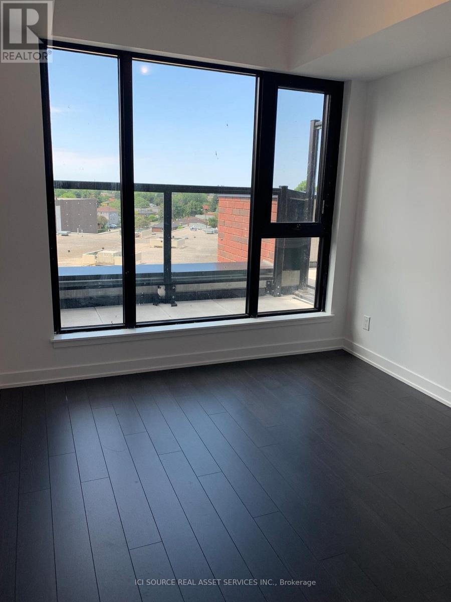 A room with a large window overlooking a parking lot.
