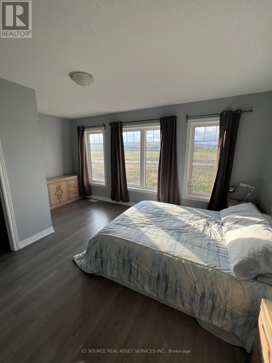 A bedroom with a large bed and a window with curtains.