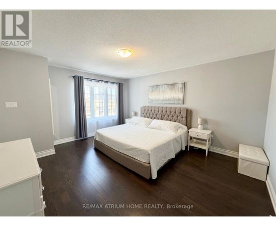 A bedroom with a large bed and a nightstand.