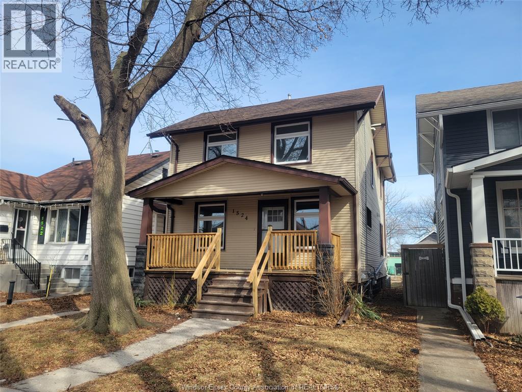 A house with a brown roof and a tree in front of it.
