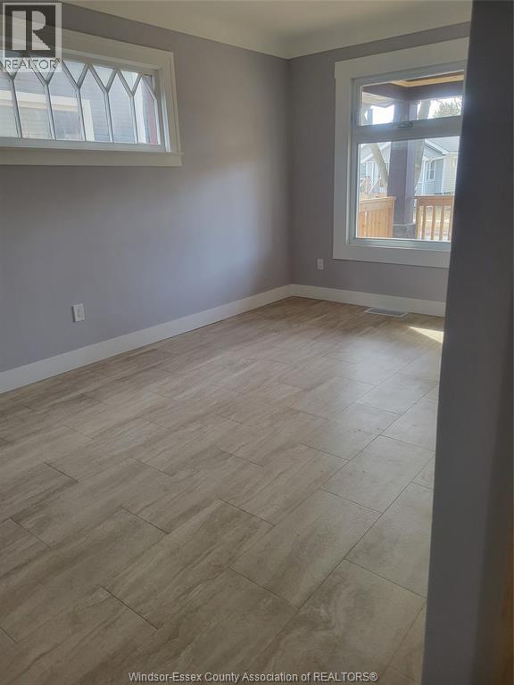 A room with a large window and wooden flooring.