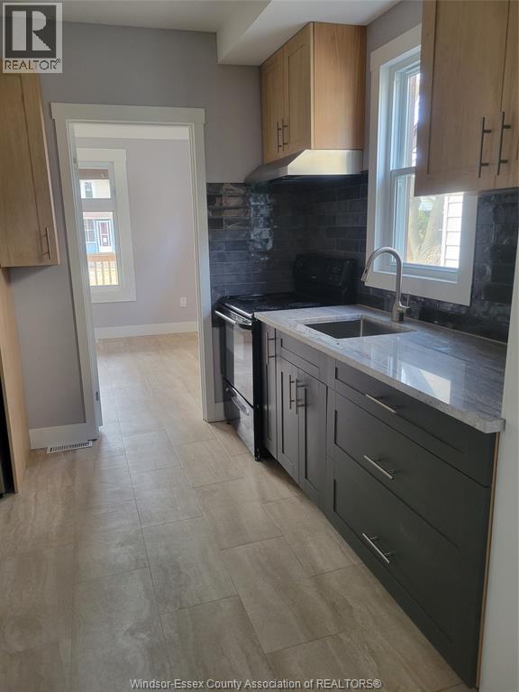 A kitchen with wooden cabinets and a black counter top.