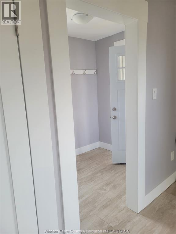 A white door is in a room with a grey wall.