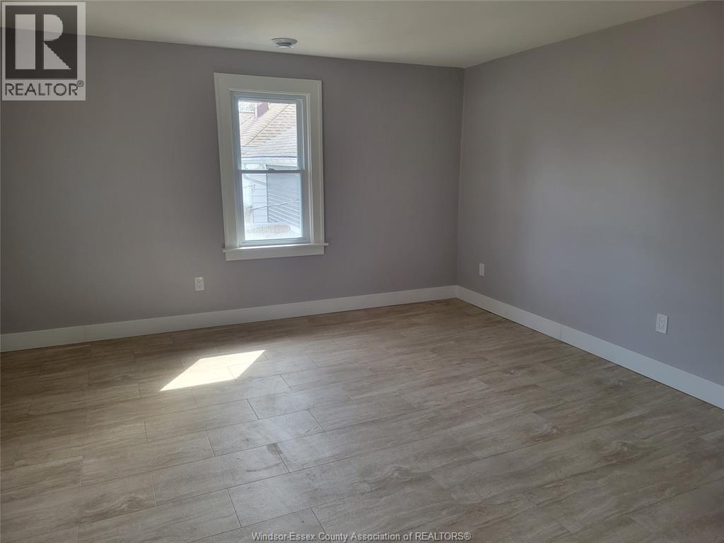 A room with a window and wooden flooring.