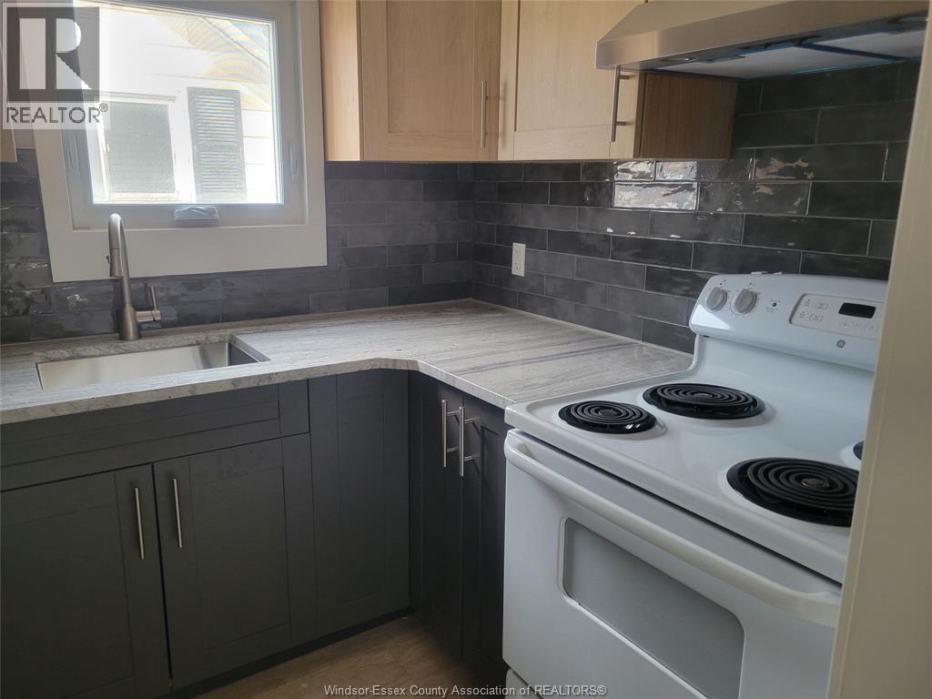 A kitchen with a white stove top oven and a window.
