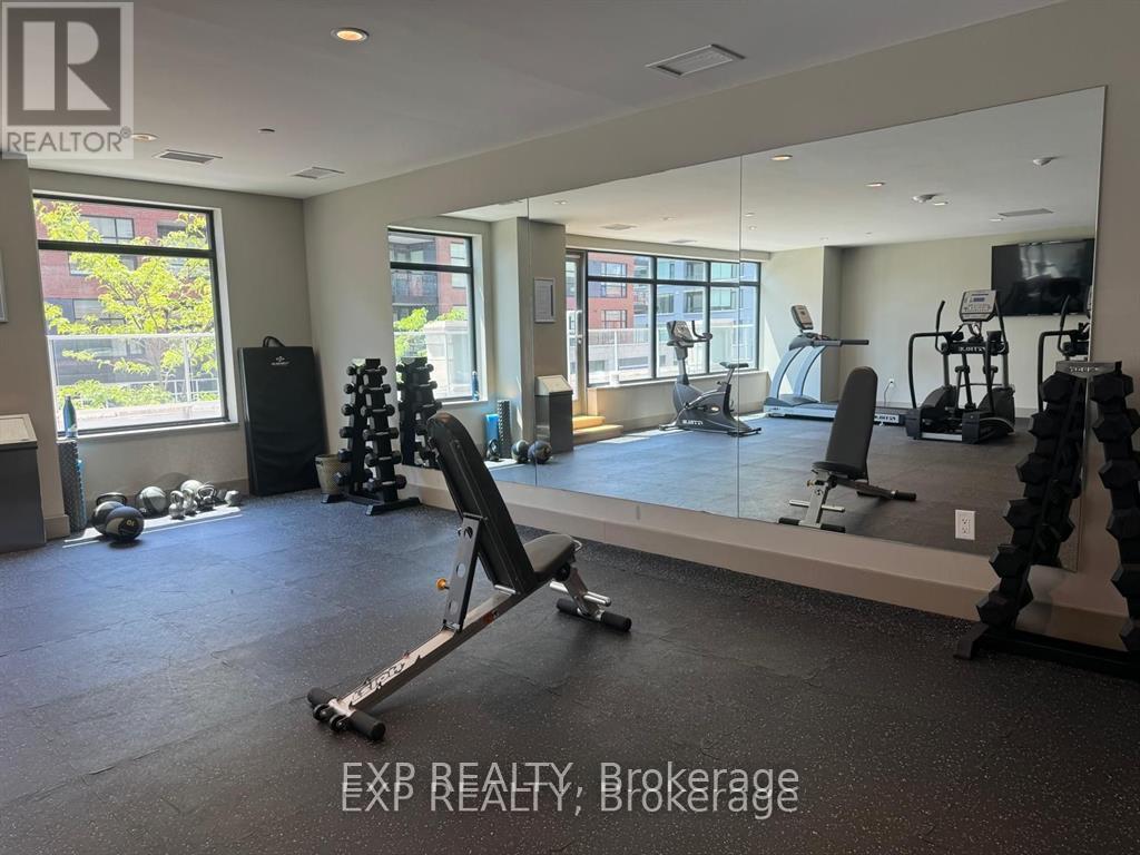 A gym with a variety of equipment including a treadmill, weights, and a mirror.