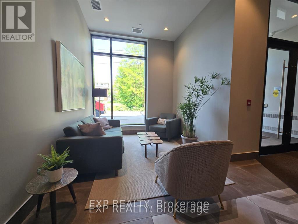 A living room with a couch, chair, and potted plants.